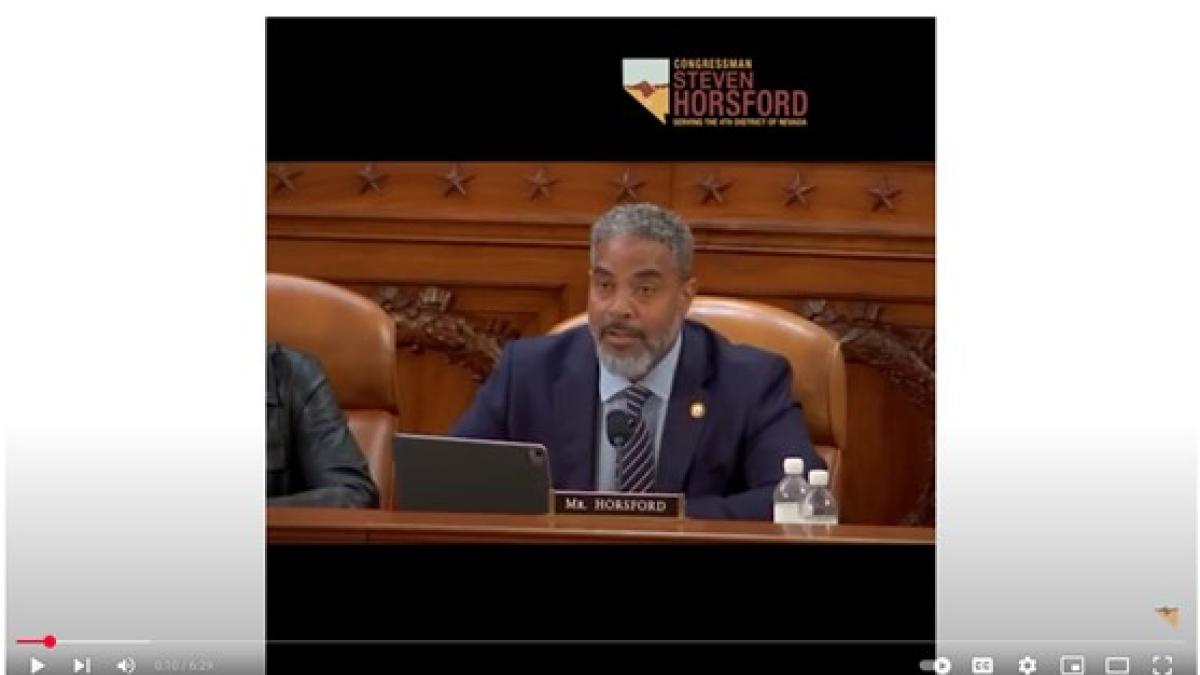 Congressman Steven Horsford speaks during a committee hearing, seated at a wooden desk with a nameplate that reads "Mr. Horsford." He wears a navy suit and speaks into a microphone, with a water bottle and laptop in front of him. The Congressional seal is engraved on the wood behind him, and his official logo appears in the upper right corner.