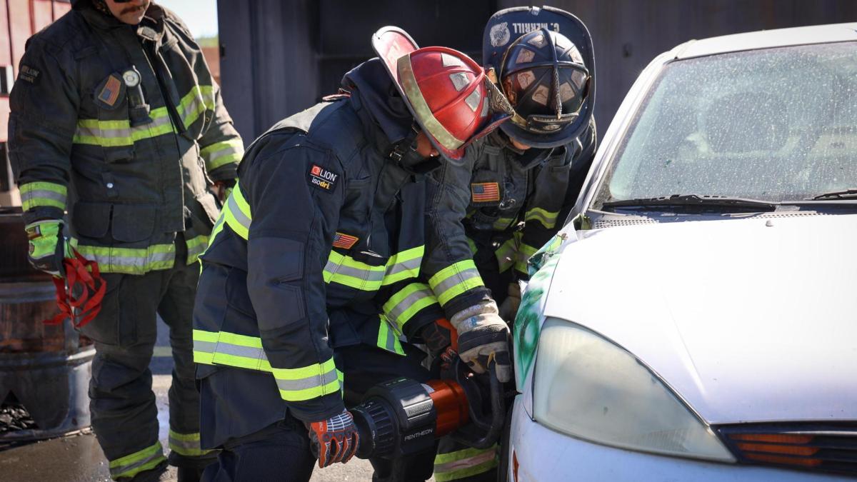 Congressman Horsford dressed as a firefighter using the "jaws of life" 