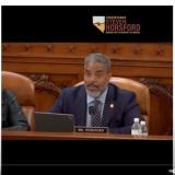 Congressman Steven Horsford speaks during a committee hearing, seated at a wooden desk with a nameplate that reads "Mr. Horsford." He wears a navy suit and speaks into a microphone, with a water bottle and laptop in front of him. The Congressional seal is engraved on the wood behind him, and his official logo appears in the upper right corner.